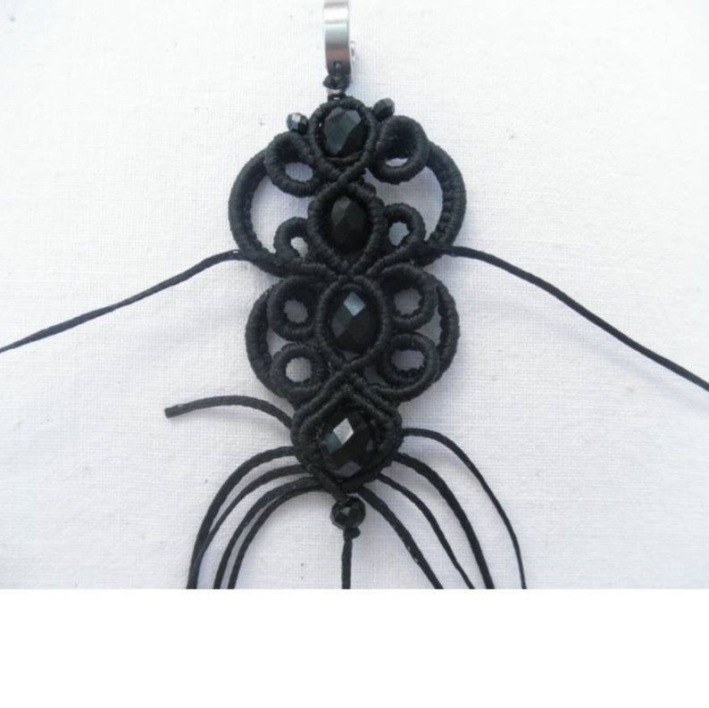 May include: Black macrame pendant with black beads and a silver loop at the top.