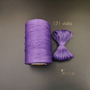 May include: A spool of purple cord with a small sample of the cord tied in a bow. The label reads "121 viola".