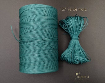 May include: A spool of teal green waxed cord, with a smaller length of the same cord next to it. The text "127 verde mare" is printed on a white background.