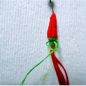 Peut inclure: Une d&eacute;coration en forme de piment rouge et vert en ficelle avec une aiguille et du fil attach&eacute;s.