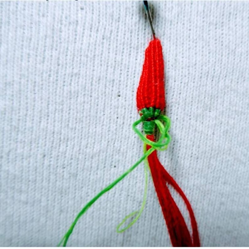 Peut inclure: Une d&eacute;coration en forme de piment rouge et vert en ficelle avec une aiguille et du fil attach&eacute;s.