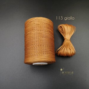 May include: A spool of brown waxed cord with a small sample of the cord next to it. The text "113 giallo" is printed above the sample.