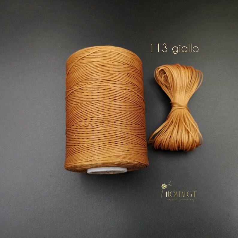 May include: A spool of brown waxed cord with a small sample of the cord next to it. The text "113 giallo" is printed above the sample.