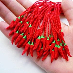 Peut inclure: Un groupe de glands en forme de piment rouge et vert. Les glands sont faits de ficelle tiss&eacute;e et sont li&eacute;s ensemble en haut.