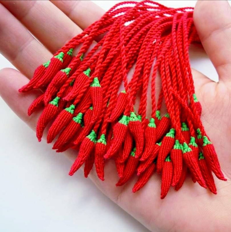 Peut inclure: Un groupe de glands en forme de piment rouge et vert. Les glands sont faits de ficelle tiss&eacute;e et sont li&eacute;s ensemble en haut.