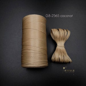 以下が含まれることがあります： 0.8-2565 coconatとラベル付けされた、0.8mm厚の薄い茶色のワックスコードのスプール。隣にはコードの長さが表示されています。