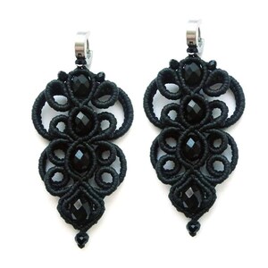 May include: A pair of black dangle earrings with intricate knotted designs and black crystal beads.