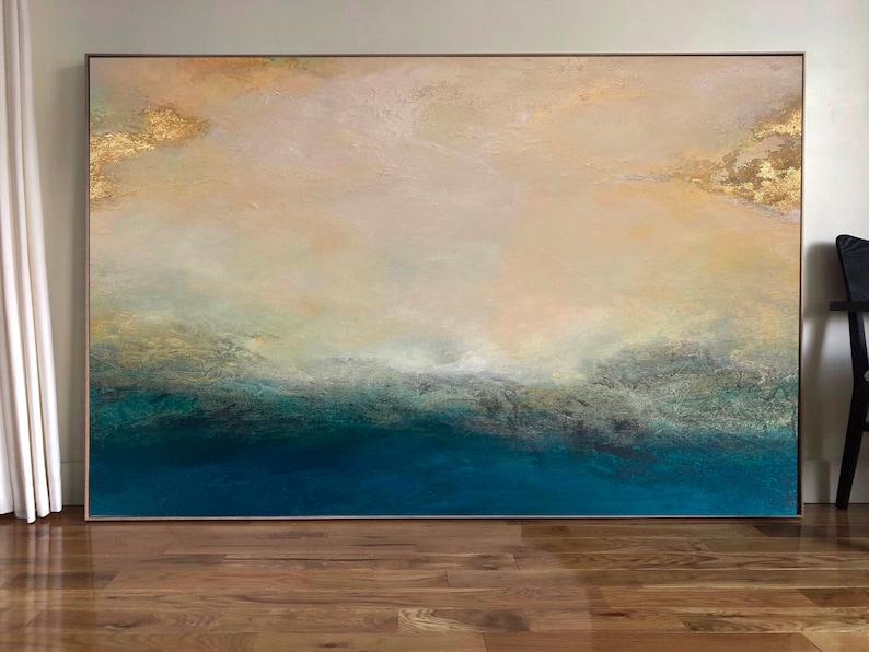 Op de afbeelding: Abstract schilderij met een lichtbeige achtergrond en een donkerblauwe onderkant. Het schilderij heeft een textuur en gouden accenten.