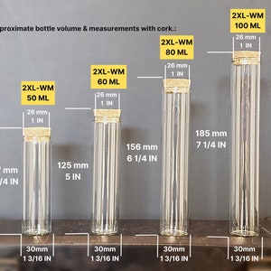 May include: Four clear glass bottles with cork stoppers and measurements in millimeters and inches. The bottles are labeled with the text "2XL-WM" and the volume in milliliters. The bottles are arranged from smallest to largest.