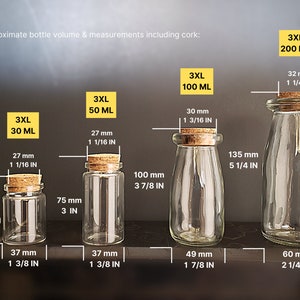 May include: Four clear glass bottles with cork stoppers and different sizes. The bottles are labeled with their volume in milliliters and inches. The bottles are arranged from smallest to largest. 3XL 30 ML, 3XL 50 ML, 3XL 100 ML, 3XL 200 ML.