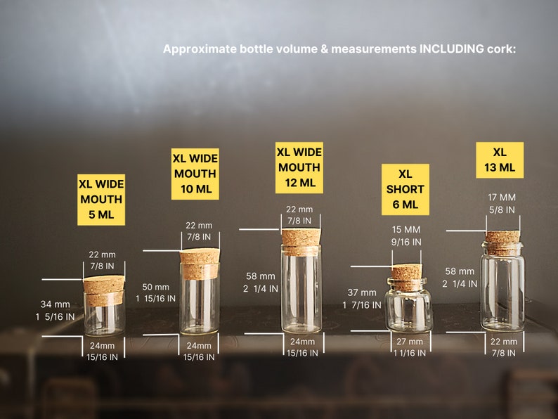 May include: Five glass bottles with cork stoppers in various sizes. The bottles are labeled with their approximate volume in milliliters and inches. The bottles are clear glass and have a round shape.