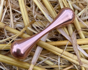May include: A rose gold fidget spinner with a smooth, rounded design. The spinner is made of metal and has a polished finish.