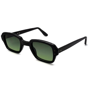 May include: Black sunglasses with a rectangular frame and green lenses. The sunglasses have a retro design with a thick frame and straight arms. The lenses are a gradient green color. The frame has small rivets on the corners.