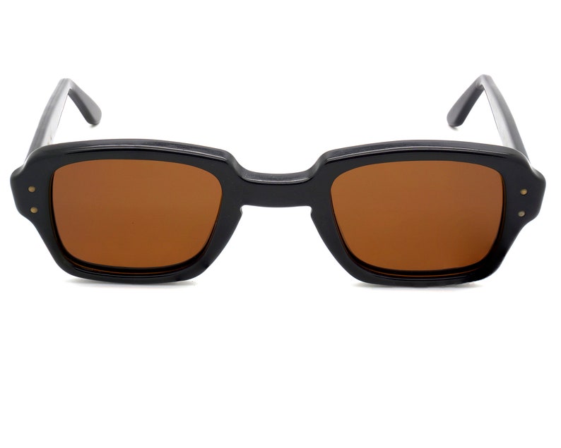 Puede incluir: Gafas de sol rectangulares negras con lentes marrones.
