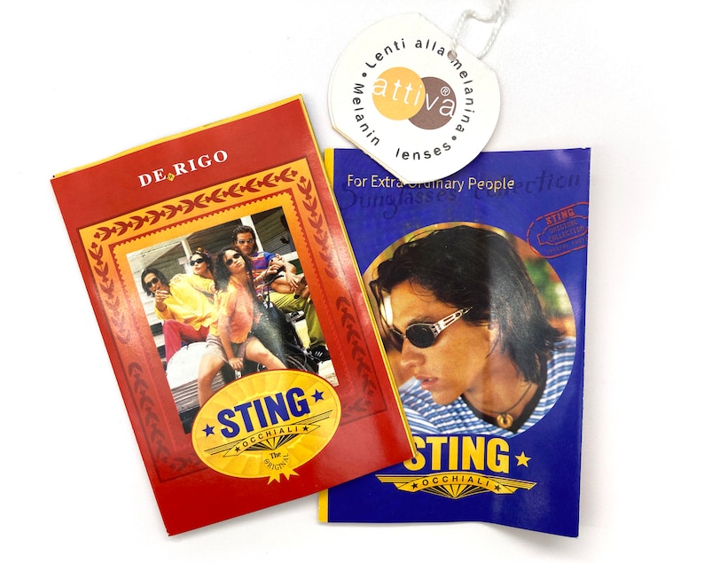 Puede incluir: Dos tarjetas promocionales rojas y azules para gafas de sol Sting. La tarjeta roja presenta a un grupo de personas con gafas de sol y el texto "DE RIGO" y "STING OCCHIALI". La tarjeta azul presenta a un hombre con gafas de sol y el texto "STING OCCHIALI".