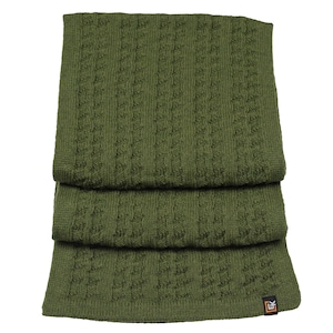Puede incluir: Una bufanda de punto verde con un patr&oacute;n de punto trenzado. La bufanda est&aacute; doblada en tres partes y la etiqueta de la marca es visible en la esquina inferior derecha.