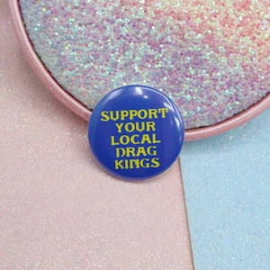 Distintivo con il pulsante "Supporta i drag king della tua zona"