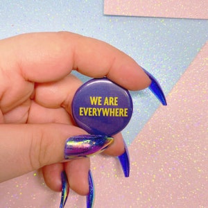 May include: A purple button with the text "WE ARE EVERYWHERE" in yellow lettering.