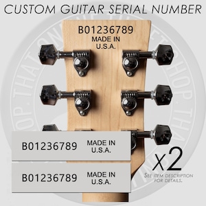 May include: Close-up of a guitar headstock with tuning pegs. The text "CUSTOM GUITAR SERIAL NUMBER" is at the top. Two labels with the text "B01236789 MADE IN U.S.A." are shown. The image also includes the text "x2 SEE ITEM DESCRIPTION FOR DETAILS."