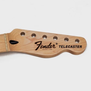 May include: A natural wood guitar neck with six tuning pegs and the text "Fender&reg; Telecaster" in black.