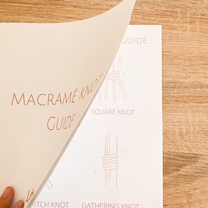 May include: A guide to macrame knots, featuring illustrations of the square knot, gathering knot, and hitch knot. The guide is printed on white paper with a light brown background.