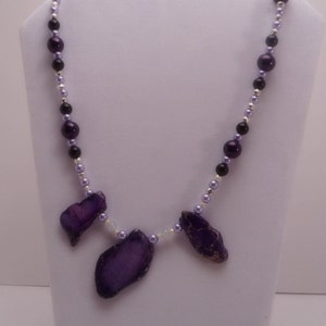 May include: A purple and silver beaded necklace with three purple agate pendant stones.