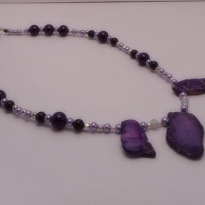 May include: A purple and silver beaded necklace with three purple agate pendant charms.