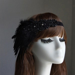 May include: A black headband with a feather and beaded embellishment. The headband is made of a soft, flexible material and is designed to fit comfortably on the head.