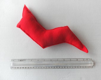 May include: A bright red, plush lightning bolt toy, approximately 10 inches long, lies on a white surface. A clear plastic ruler is positioned below the toy for scale. The toy is made of soft fabric.