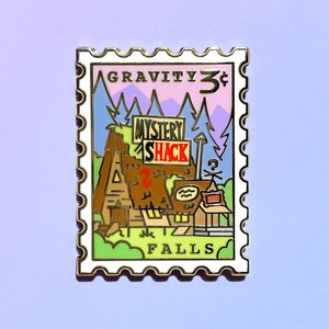 May include: A gold-colored enamel pin shaped like a postage stamp with the text "GRAVITY FALLS" and "MYSTERY SHACK" on it. The pin features a cartoon image of a building with a sign that says "MYSTERY SHACK" and a mountain range in the background.