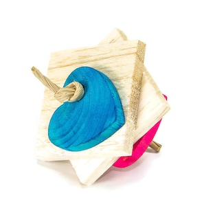 May include: A wooden toy with a blue heart shape on one side and a pink heart shape on the other. The toy is attached to a string and can be spun around.