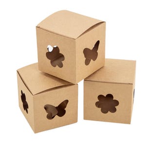 May include: Three light brown square cardboard boxes with fold-over lids. Each box features die-cut openings in the shapes of butterflies and flowers on the sides, allowing for visibility into the interior of the containers.