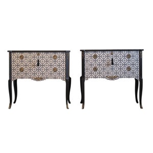 May include: Two black and white patterned bedside tables with gold accents and ornate legs. The bedside tables have a geometric design with a keyhole in the centre.
