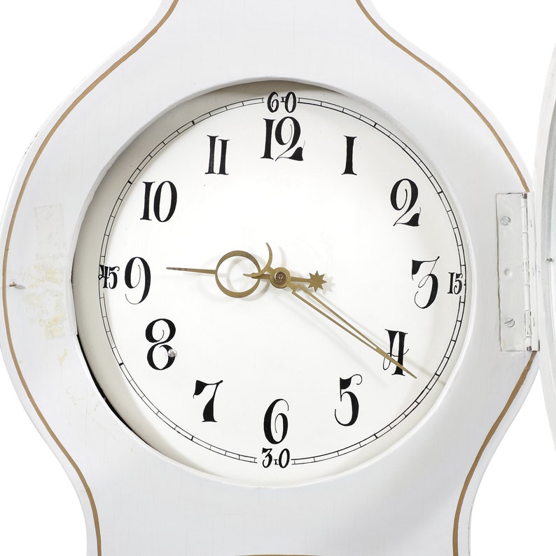 May include: White wooden clock face with black Roman numeral hour markers and black Arabic numeral minute markers. The clock hands are gold.