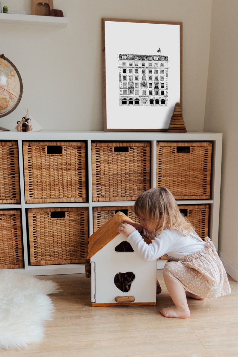 Puede incluir: Una casa de juegos de madera blanca con un techo marr&oacute;n, un ni&ntilde;o est&aacute; jugando con la casa.