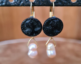 Könnte beinhalten: Schwarze Kameen-Ohrringe mit einer goldenen Fassung und einem Perlenanhänger.
