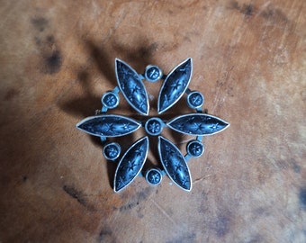 Broche Belle Epoque en argent et jais (?) en forme de rosace avec étoiles gravées