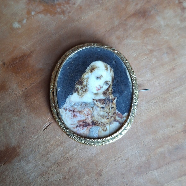 Broche XIX ovale avec miniature de petite fille ave chat peint sur nacre avec cadre en métal doré ciselé