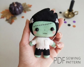 May include: A small, handmade felt doll featuring a light green face with black hair, a stitched forehead scar, and black bead eyes. The doll wears a white shirt with a small patch detail and black pants. The text PDF SEWING PATTERN is visible.