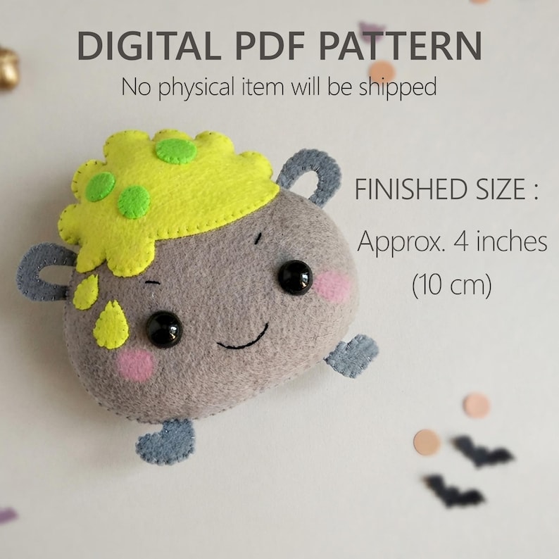 May include: A digital PDF pattern for a felt plushie shaped like a grey cauldron with a yellow bubbling top, black eyes, and pink cheeks. The text reads DIGITAL PDF PATTERN, No physical item will be shipped, and FINISHED SIZE: Approx. 4 inches.