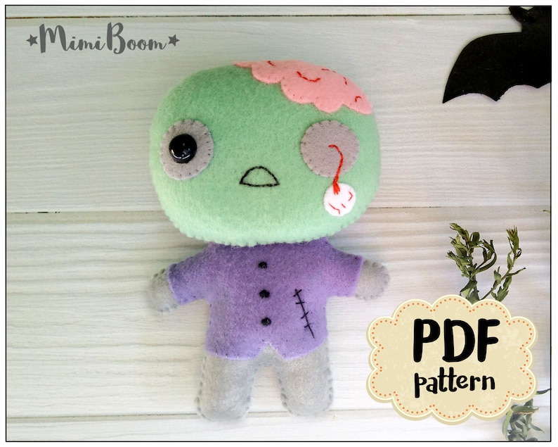 May include: A handmade felt zombie doll with a green head, pink brain, and a purple shirt. The doll has a black button eye and a stitched mouth. The text "PDF pattern" is visible.