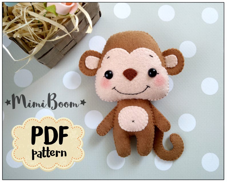 May include: A brown felt monkey toy with a pink face and a brown tail. The toy is on a white background with gray polka dots. The text "*MimiBoom* PDF pattern" is in the lower left corner of the image.