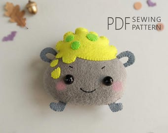 Pode incluir: Um caldeirão de feltro cinza com duas alças, um rosto sorridente e bochechas rosadas. O topo apresenta um líquido amarelo borbulhante com manchas verdes. O texto PDF SEWING PATTERN é visível no canto superior direito, com formas de feltro.
