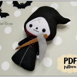 May include: A handmade felt Grim Reaper doll with a black hooded robe, a white skull face, and a gray scythe. The doll has black button eyes and a red collar. The image includes the text "MimiBoom" and "PDF Pattern".