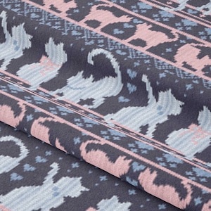 May include: A dark blue fabric with a repeating pattern of pink and blue cats. The cats are in a standing position and have a simple design. The fabric has a knitted texture.