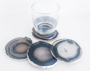 Dessous de verre en agate grise naturelle avec bordure en feuille d'argent. Ensemble de sous-bocks géode en cristal arrondis faits main.