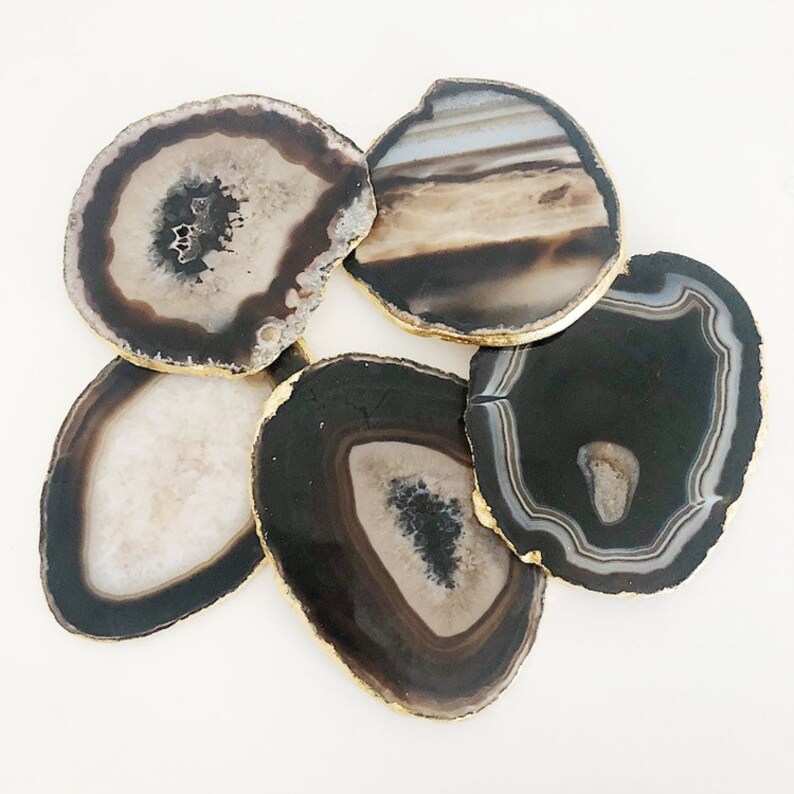 May include: Set of six agate coasters with gold trim. Each coaster features a unique natural pattern of black, white, and brown agate.