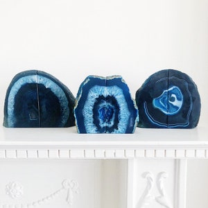 May include: Three blue agate bookends. The bookends are made of natural agate and have a unique, swirling pattern. They are perfect for adding a touch of natural beauty to your home.