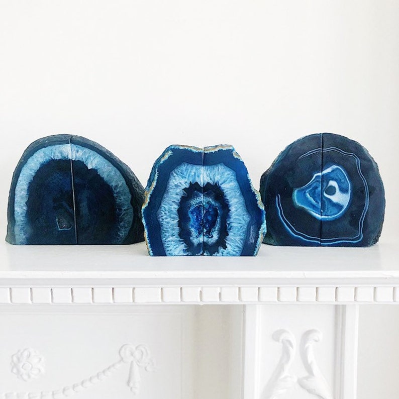 May include: Three blue agate bookends. The bookends are made of natural agate and have a unique, swirling pattern. They are perfect for adding a touch of natural beauty to your home.