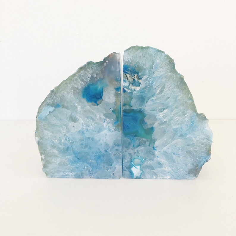 May include: A pair of blue agate bookends. The bookends are made from natural agate and have a unique, organic shape. They are perfect for adding a touch of natural beauty to your home.